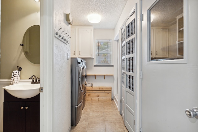 kitchen featuring white cabinets, independent washer and dryer, a textured ceiling, and sink