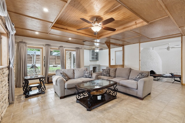 living room with a tray ceiling, ceiling fan, a fireplace, and wooden ceiling