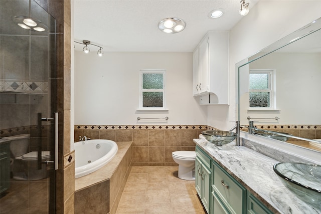 full bathroom featuring tile patterned floors, separate shower and tub, a textured ceiling, toilet, and vanity