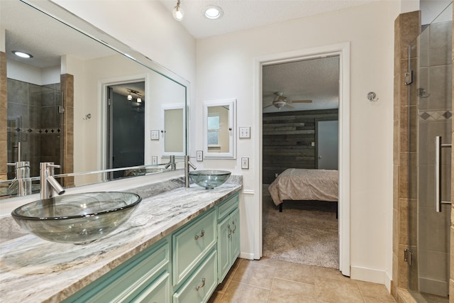 bathroom with vanity, tile patterned floors, ceiling fan, a textured ceiling, and an enclosed shower