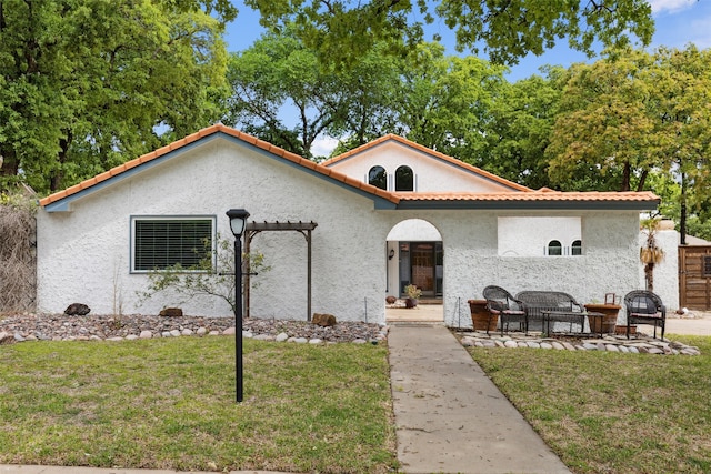 mediterranean / spanish-style house with a patio and a front yard