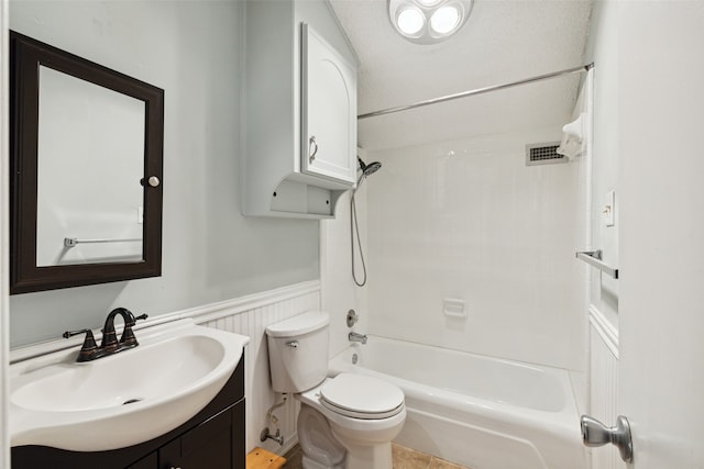 full bathroom featuring a textured ceiling, vanity, toilet, and tiled shower / bath