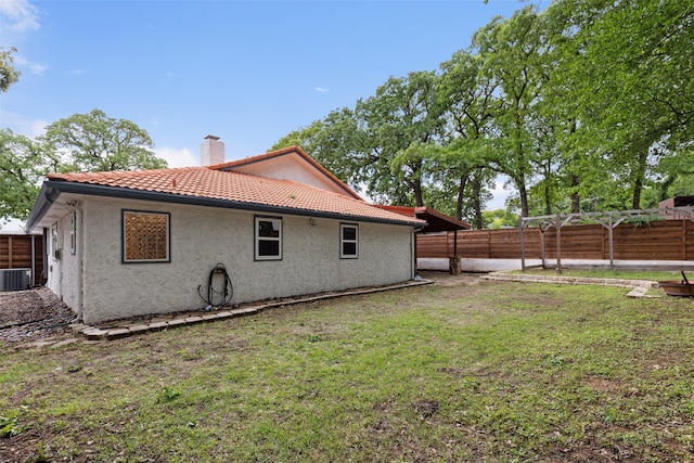 back of house with a lawn and central air condition unit