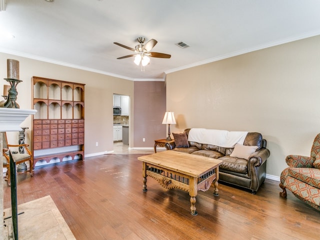 living room featuring hardwood / wood-style floors, crown molding, and ceiling fan