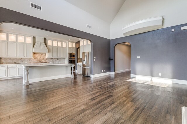 unfurnished living room with high vaulted ceiling and dark hardwood / wood-style floors