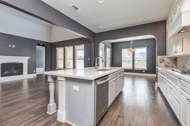 kitchen with a healthy amount of sunlight, sink, white cabinetry, and an island with sink