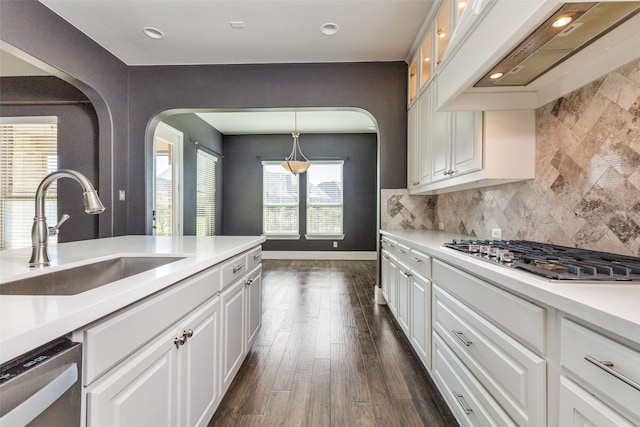 kitchen with custom exhaust hood, white cabinets, sink, dark hardwood / wood-style floors, and decorative backsplash