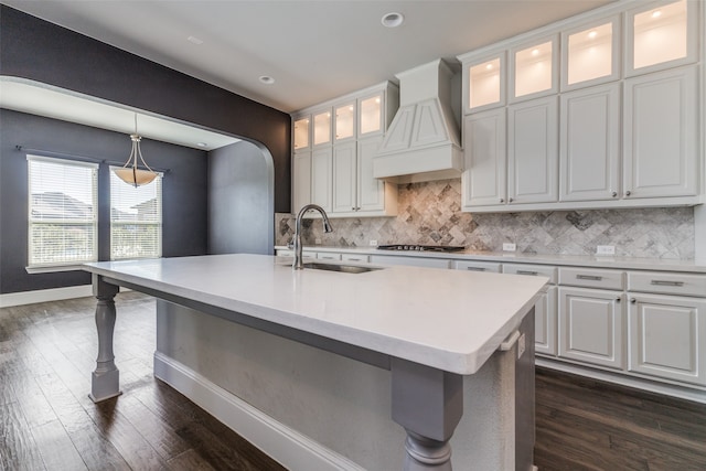 kitchen with sink, dark hardwood / wood-style flooring, a kitchen island with sink, white cabinets, and custom range hood