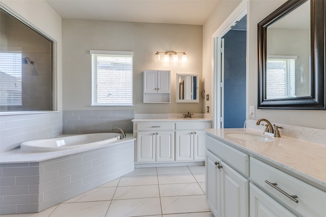 bathroom with vanity and a relaxing tiled tub