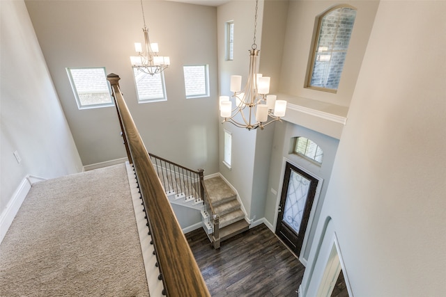 entrance foyer featuring dark hardwood / wood-style floors, a towering ceiling, and a chandelier