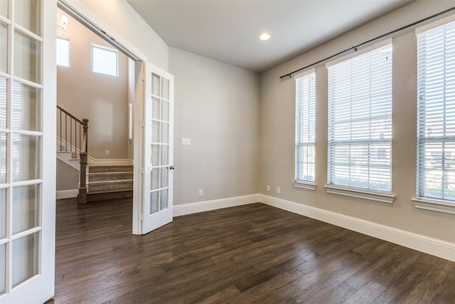 empty room with plenty of natural light and dark wood-type flooring