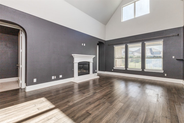 unfurnished living room featuring wood-type flooring and high vaulted ceiling