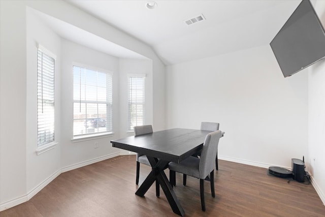 dining area with dark wood-type flooring and lofted ceiling