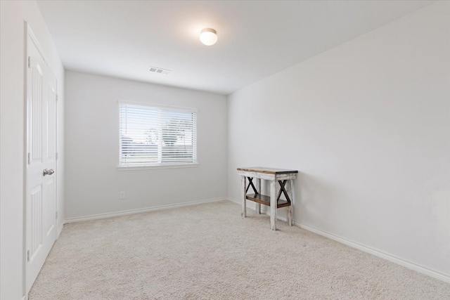 unfurnished room featuring light carpet