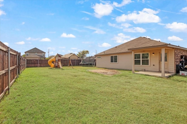 view of yard with a trampoline, a playground, and a patio area