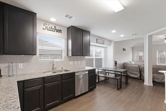 kitchen with a wealth of natural light, sink, stainless steel dishwasher, and wood-type flooring