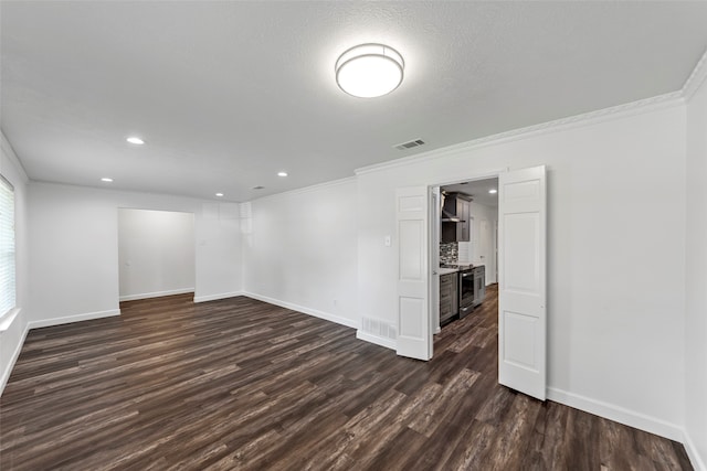 empty room featuring dark hardwood / wood-style flooring, ornamental molding, and a textured ceiling