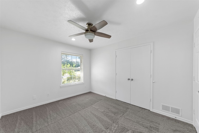 unfurnished bedroom featuring carpet flooring, ceiling fan, a closet, and a textured ceiling