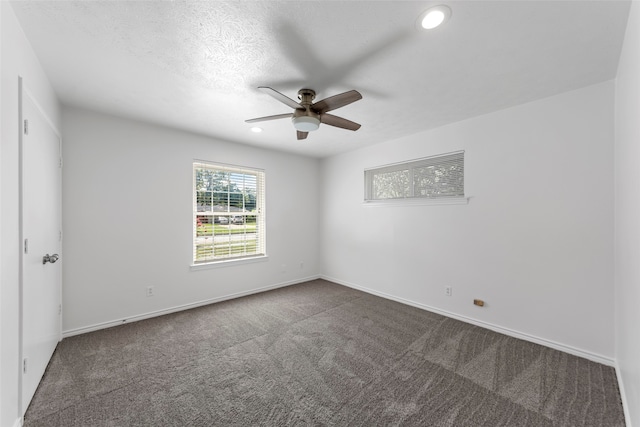 carpeted spare room with a textured ceiling and ceiling fan