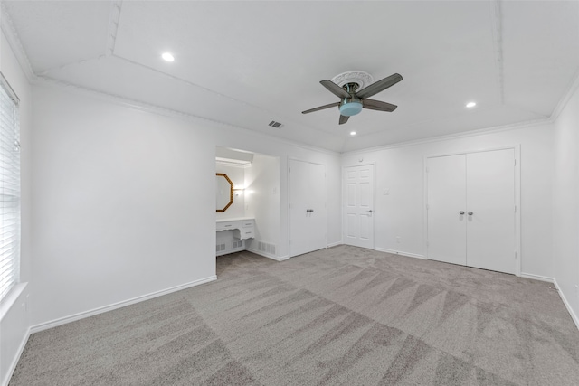 unfurnished bedroom featuring ceiling fan, light colored carpet, and crown molding