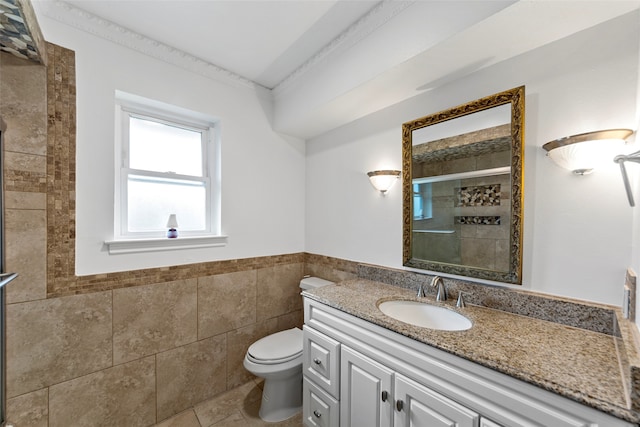 bathroom with an enclosed shower, vanity, tile walls, tile patterned flooring, and toilet