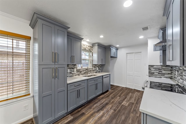 kitchen featuring dishwasher, dark hardwood / wood-style floors, gray cabinets, and ornamental molding