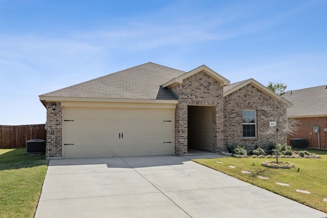 view of front of property with central AC, a front yard, and a garage