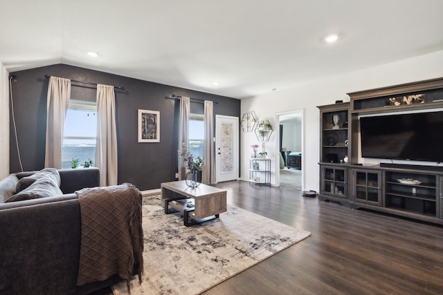 living room with dark hardwood / wood-style floors, a healthy amount of sunlight, a water view, and vaulted ceiling