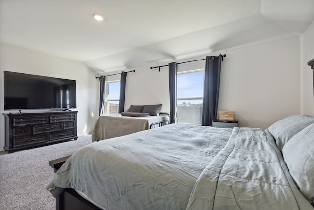 carpeted bedroom with vaulted ceiling and multiple windows