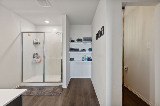 bathroom featuring hardwood / wood-style floors, vanity, and a shower with door