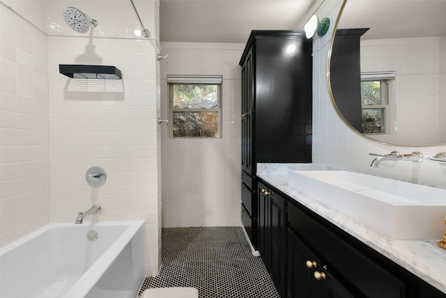 bathroom featuring tile patterned flooring, vanity, a healthy amount of sunlight, and tiled shower / bath