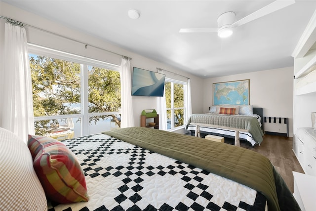 bedroom with ceiling fan, wood-type flooring, and radiator