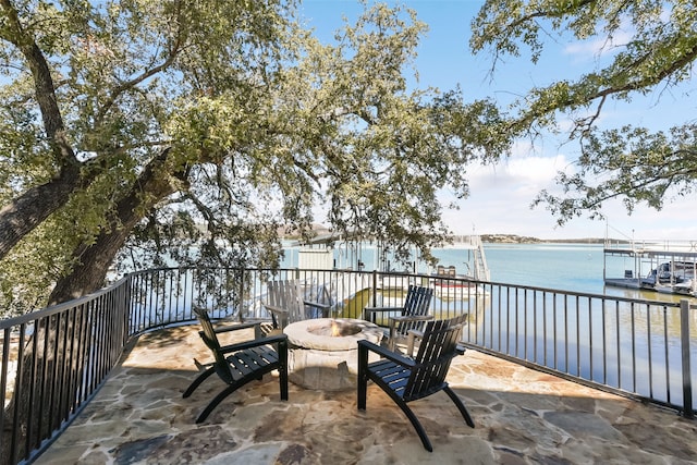 view of patio with a water view and a fire pit