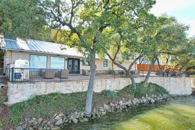 rear view of property with a water view and french doors