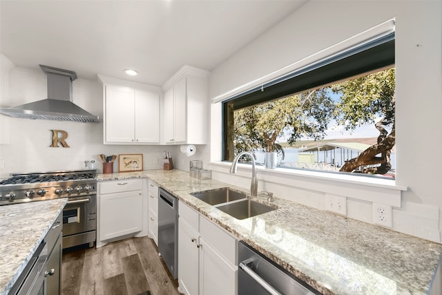 kitchen featuring white cabinetry, sink, wall chimney exhaust hood, and stainless steel appliances