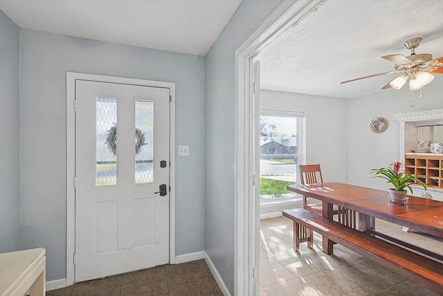 doorway featuring ceiling fan and tile patterned flooring