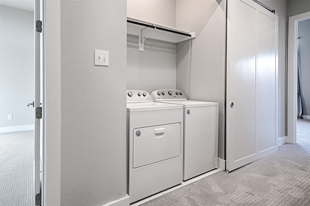 laundry area featuring light carpet and washing machine and clothes dryer