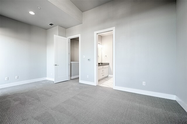 unfurnished bedroom with light colored carpet and ensuite bath