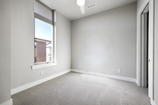 carpeted spare room featuring ceiling fan