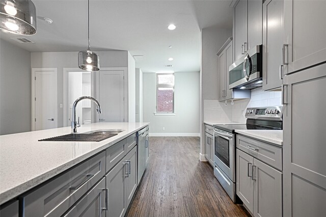 kitchen with sink, stainless steel appliances, dark hardwood / wood-style floors, decorative light fixtures, and gray cabinets