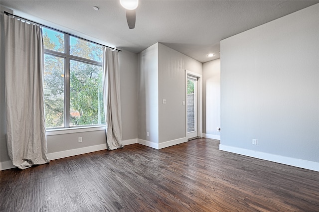 spare room featuring dark hardwood / wood-style flooring, a wealth of natural light, and ceiling fan