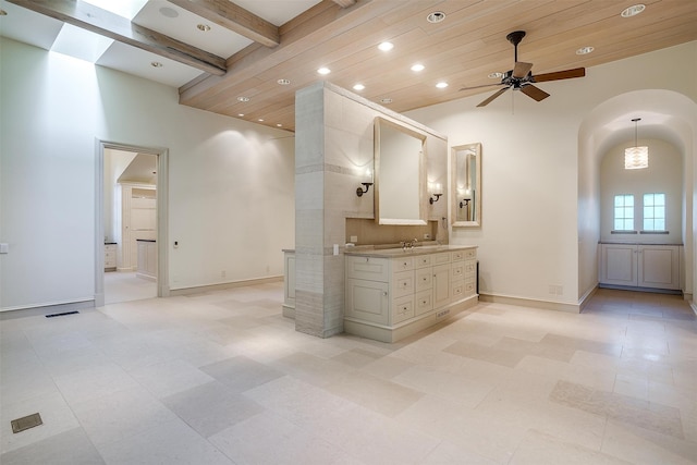 kitchen featuring ceiling fan, wooden ceiling, backsplash, and a high ceiling