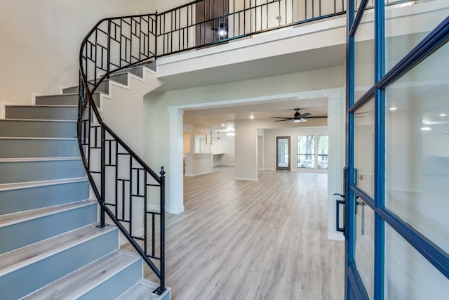 stairway featuring french doors, hardwood / wood-style flooring, and ceiling fan