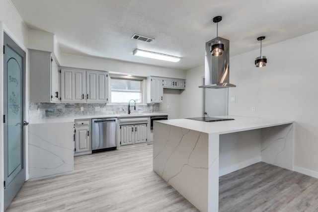 kitchen featuring light hardwood / wood-style flooring, kitchen peninsula, pendant lighting, extractor fan, and black appliances