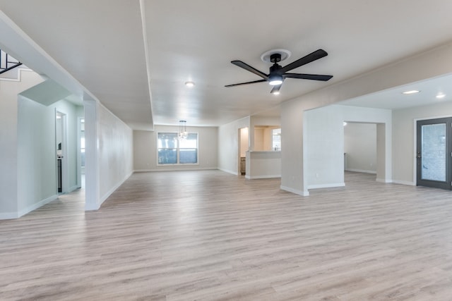 unfurnished living room with light hardwood / wood-style flooring and ceiling fan with notable chandelier