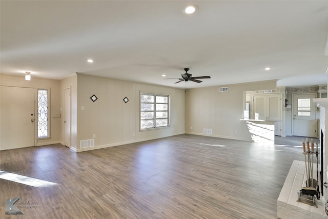 unfurnished living room featuring hardwood / wood-style floors, a brick fireplace, and ceiling fan