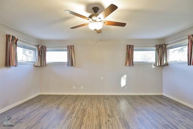 empty room featuring a wealth of natural light, ceiling fan, and hardwood / wood-style flooring