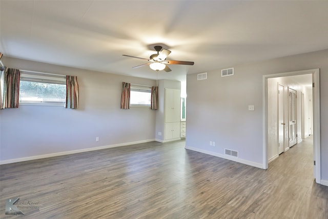 unfurnished room with hardwood / wood-style floors, a wealth of natural light, and ceiling fan