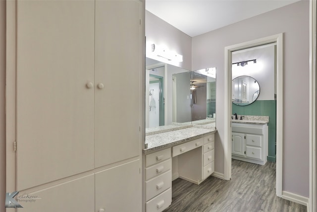 bathroom with hardwood / wood-style floors, vanity, and ceiling fan