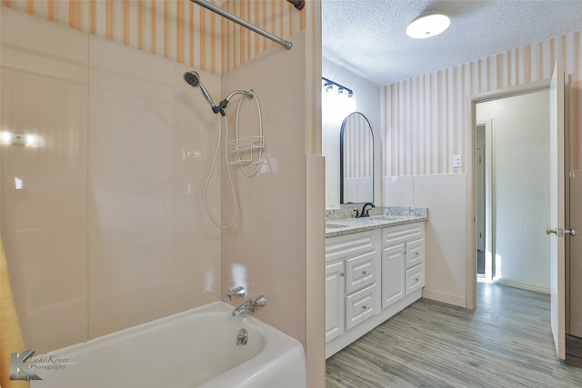 bathroom with vanity, wood-type flooring, a textured ceiling, and shower / tub combination